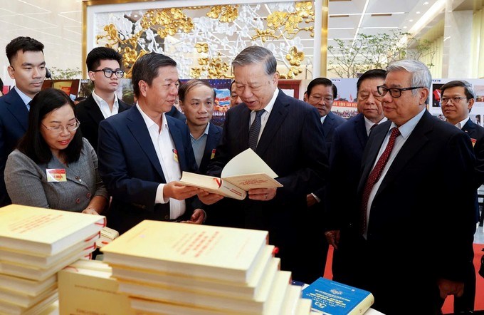 Tổng Bí thư Tô Lâm và các đại biểu tham quan không gian trưng bày sách, triển lãm ảnh và thành tựu chuyển đổi số trong báo chí. (Ảnh: SGGP)