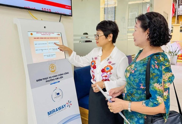 C&ocirc;ng chức tại Điểm tiếp nhận, phục vụ h&agrave;nh ch&iacute;nh c&ocirc;ng phường Kim Li&ecirc;n hướng dẫn người d&acirc;n lấy số để thực hiện c&aacute;c thủ tục h&agrave;nh ch&iacute;nh.