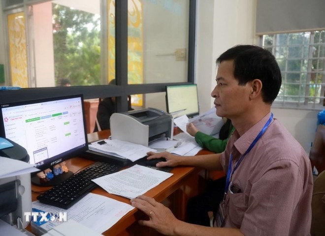 C&aacute;n bộ Tư ph&aacute;p-Hộ tịch giải quyết thủ tục h&agrave;nh ch&iacute;nh cho c&ocirc;ng d&acirc;n (Ảnh TTXVN)