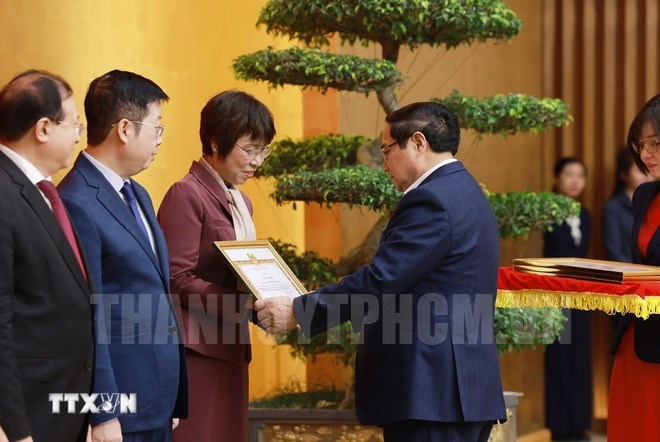 Thủ tướng Phạm Minh Ch&iacute;nh trao Bằng khen của Ban Chấp h&agrave;nh Đảng bộ Ch&iacute;nh phủ cho đồng ch&iacute; Vũ Việt Trang, Tổng Gi&aacute;m đốc Th&ocirc;ng tấn x&atilde; Việt Nam. (Ảnh: TTXVN)