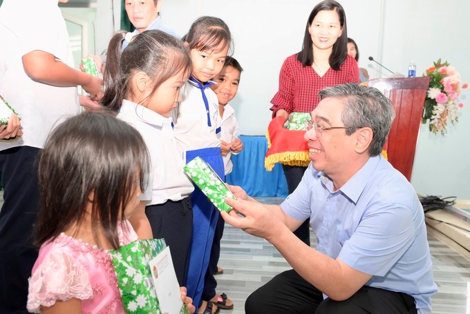 Đồng ch&iacute; Nguyễn Phước Lộc trao qu&agrave; tết đến c&aacute;c em học sinh. (Ảnh: SGGP)