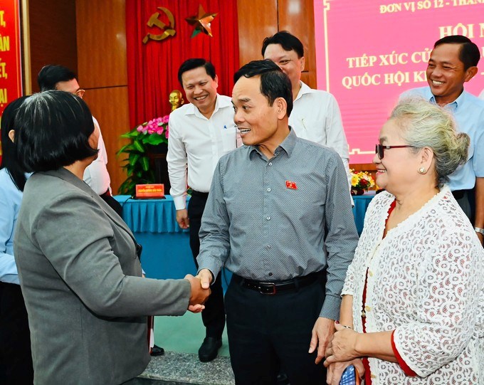 Bí thư Thành ủy TPHCM Trần Lưu Quang trò chuyện với cử tri sau buổi tiếp xúc. (Ảnh SGGP)