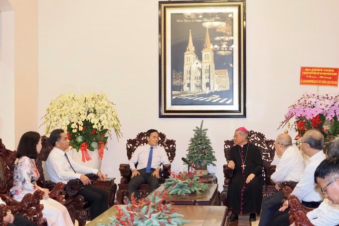 Bí thư Thành ủy TPHCM Trần Lưu Quang trao đổi với Đức Tổng Giám mục Giuse Nguyễn Năng. (Ảnh: SGGP)