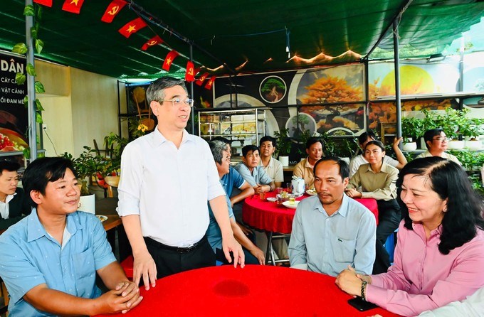 Đồng ch&iacute; Nguyễn Phước Lộc thăm hỏi người d&acirc;n trồng mai ở x&atilde; B&igrave;nh Lợi. (Ảnh: SGGP)