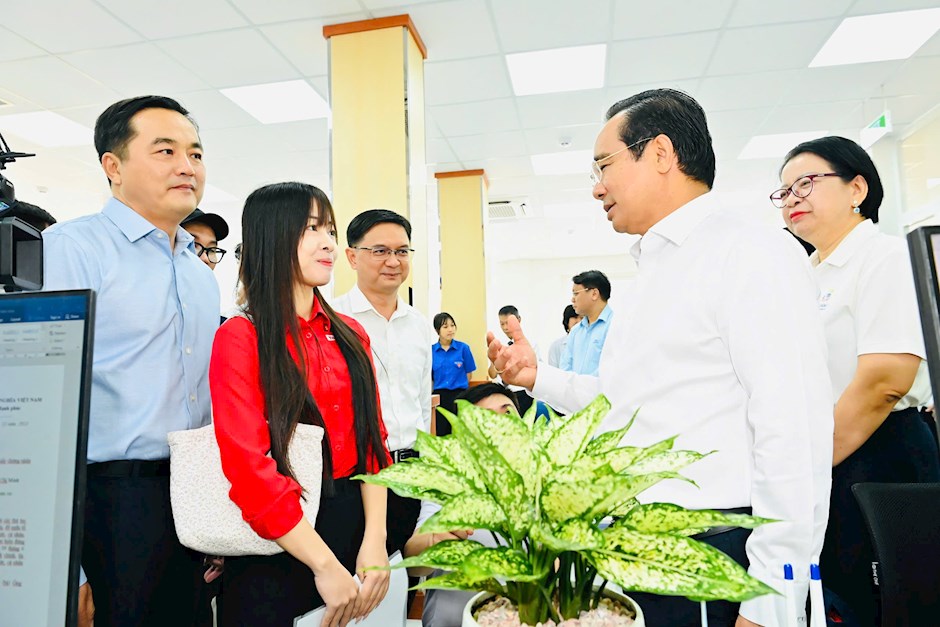 Chủ tịch UBND TPHCM trao đổi c&ugrave;ng người d&acirc;n đến thực hiện thủ tục h&agrave;nh ch&iacute;nh. Ảnh: SGGP