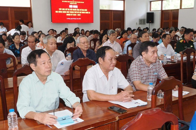 Cử tri nghe chương trình hành động của những người ứng cử. (Ảnh: SGGP)