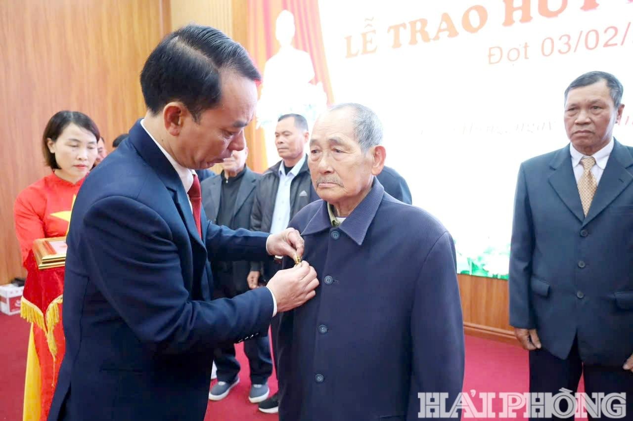 Phó bí thư Thường trực Đảng ủy xã Chấn Hưng Vũ Văn Hè trao Huy hiệu Đảng tặng đảng viên tại buổi lễ.