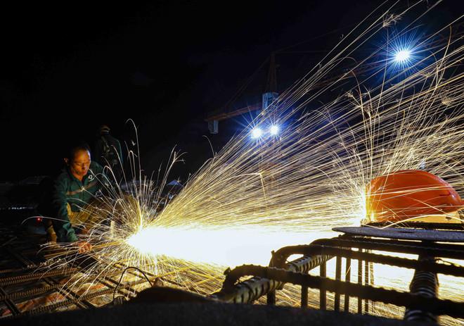 Trên công trường xây dựng Trường Liên cấp Tiểu học – Trung học cơ sở xã Si Pa Phìn (tỉnh Điện Biên) - trường khởi công đầu tiên trong số 100 trường, hơn 400 công nhân chia ca làm việc xuyên ngày đêm để kịp tiến độ. (Ảnh: Xuân Tư/TTXVN) vna-potal-xuyen-dem-tren-cong-truong-xay-dung-truong-lien-cap-vung-bien-si-pa-phin-dien-bien-8392752.jpg