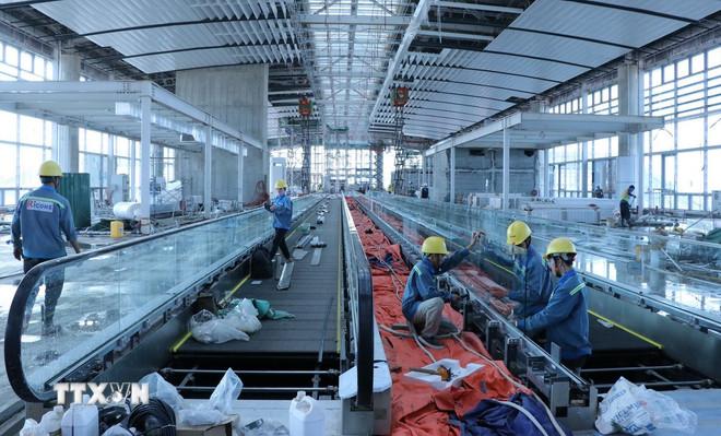 Nhân viên kỹ thuật hoàn thiện cầu thang bộ hành nhà ga hành khách sân bay Long Thành. (Ảnh: Công Phong/TTXVN) ttxvn-san-bay-long-thanh2.jpg