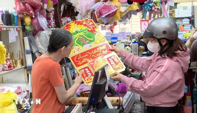 Người dân mua lịch năm mới. (Ảnh: Huyền Trang/TTXVN) ttxvn-mua-lich-tet-1.jpg