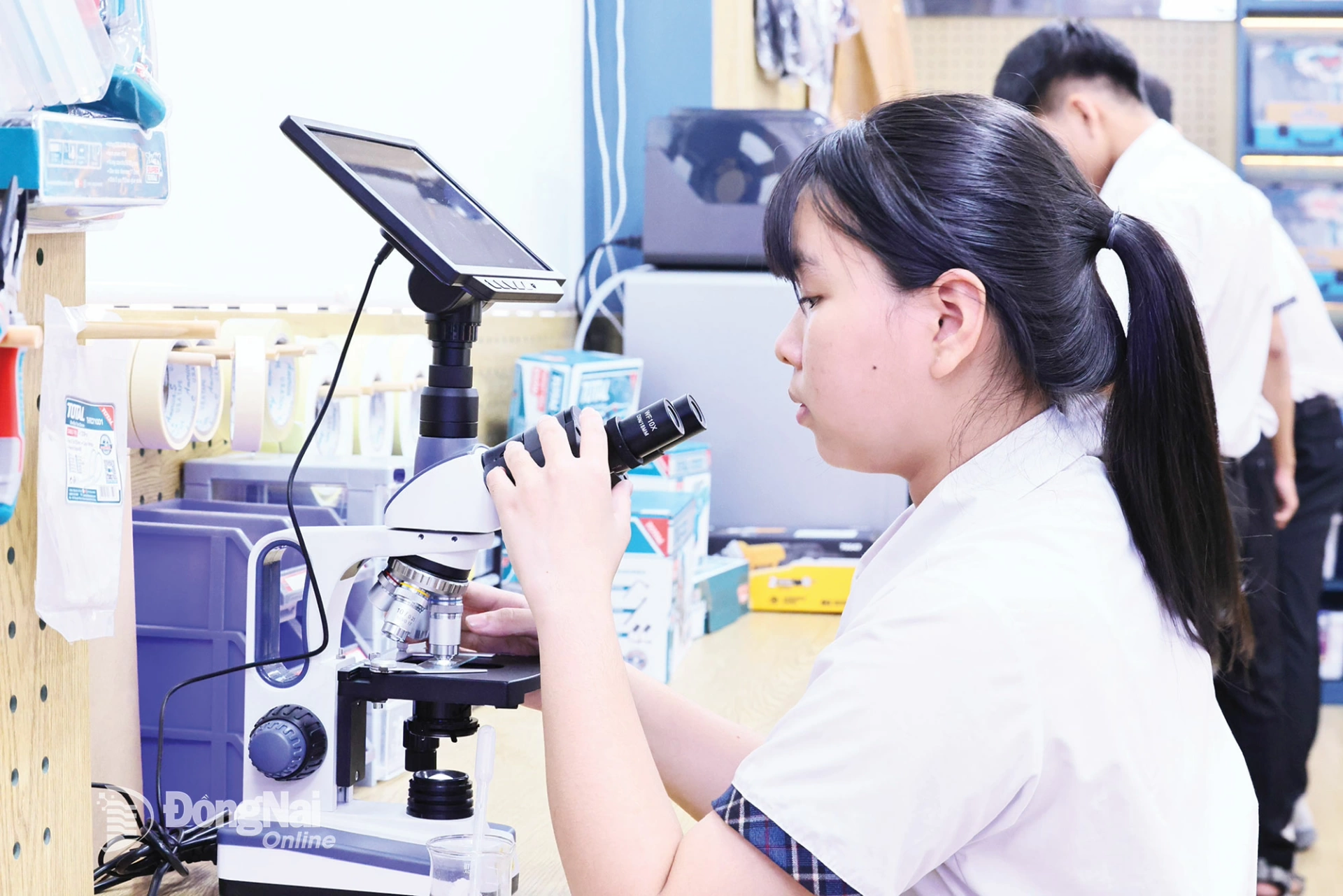 Học sinh thực h&agrave;nh thao t&aacute;c với k&iacute;nh hiển vi điện tử.