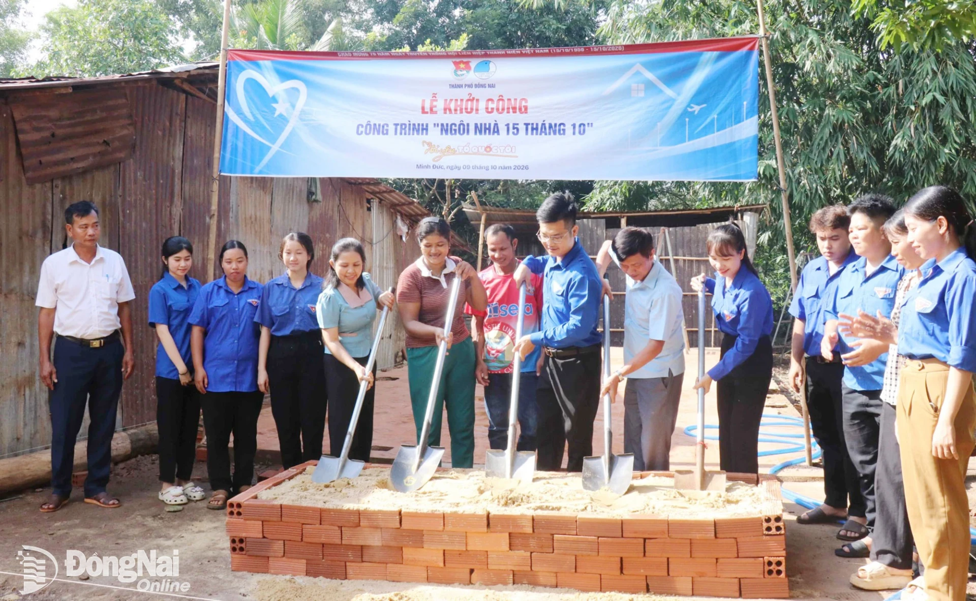 Các đại biểu thực hiện nghi thức khởi công Ngôi nhà 15 tháng 10 cho gia đình chị Thị Lan (áo nâu, ở giữa) tại xã Minh Đức. Ảnh: Ngọc Huyền