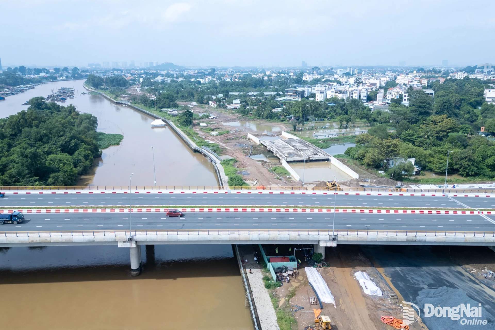Cầu Thống Nhất đã thông xe, trong khi bên dưới, các hạng mục của đường ven sông Cái tiếp tục được đẩy nhanh, từng bước hoàn thiện mạng lưới giao thông khu vực. Ảnh: Xuân Lượng 