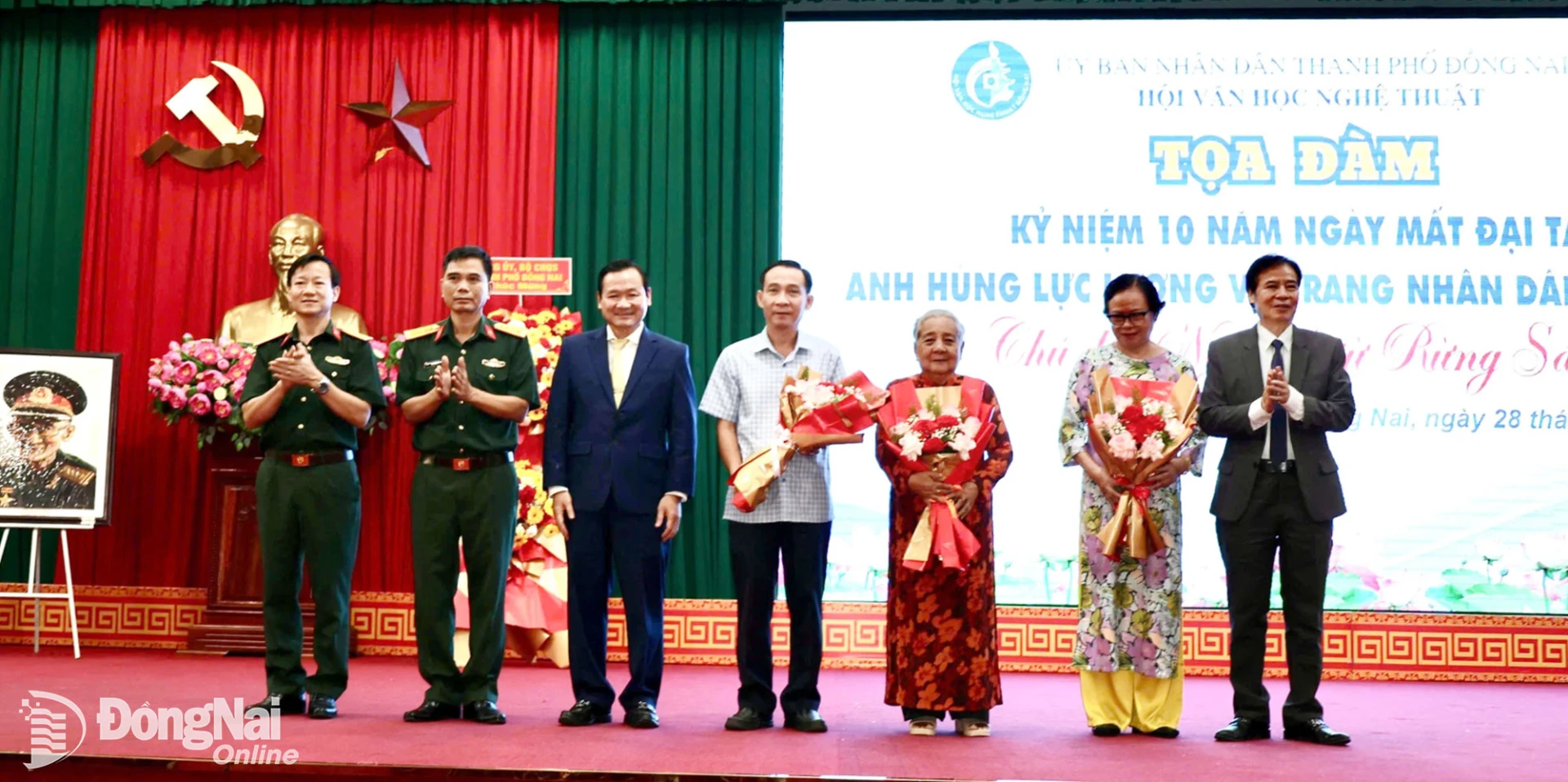 Đại diện Ban Tổ chức tọa đàm tặng hoa cảm ơn gia đình cố Đại tá, Anh hùng Lực lượng vũ trang nhân dân Lê Bá Ước. Ảnh: Nguyệt Hà
