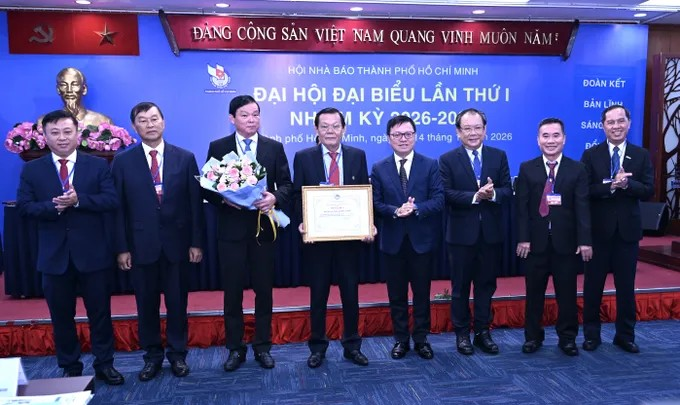 Đồng chí Lê Quốc Minh trao Bằng khen của Hội Nhà báo Việt Nam tặng tập thể Hội Nhà báo TPHCM nhiệm kỳ 2020-2026. Ảnh: VĂN MINH