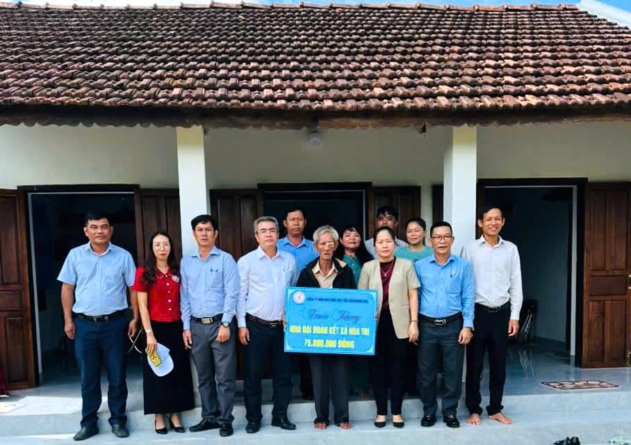 Lãnh đạo xã và đơn vị tài trợ trao bảng tượng trưng kinh phí hỗ trợ cho ông Sâm.