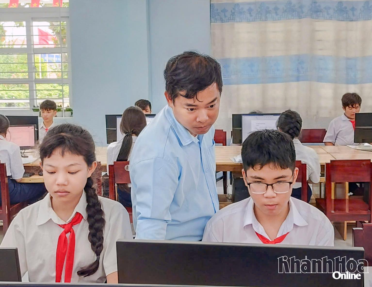 Anh Phạm Thanh Mân hướng dẫn học sinh trong giờ học Tin học.