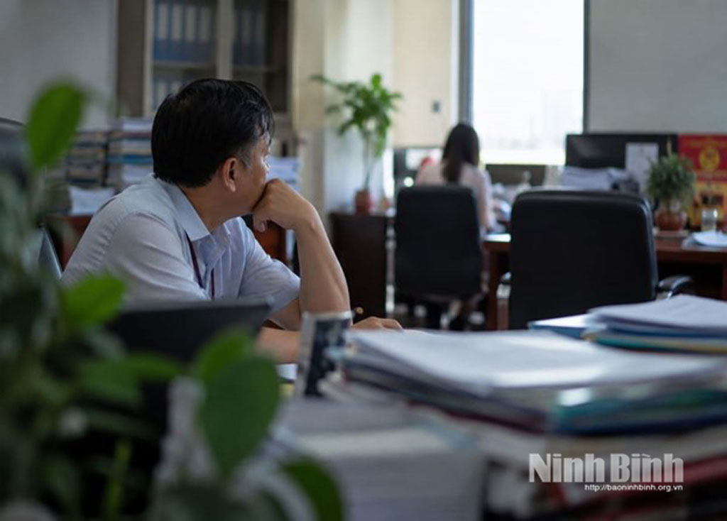 Khoảnh khắc trầm tư của một cán bộ giữa chồng hồ sơ công việc (Ảnh mang tính chất minh họa).