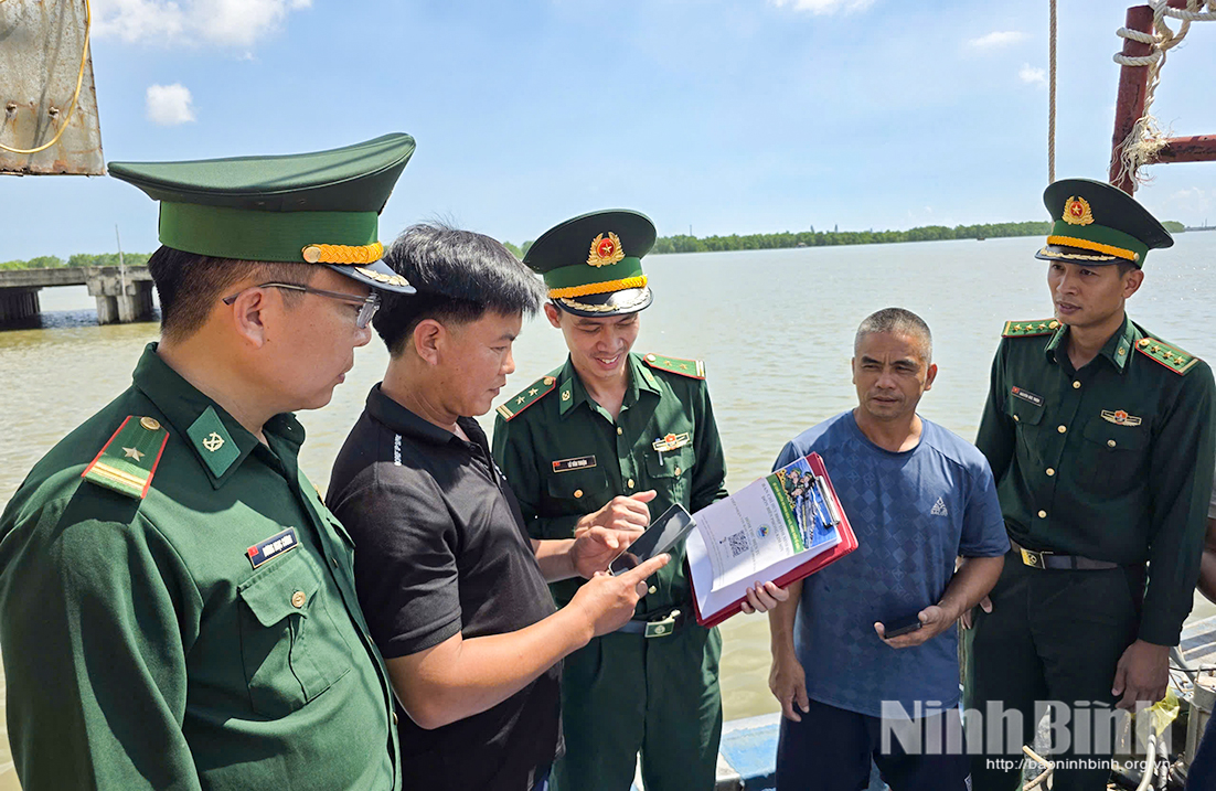 Cán bộ Đồn Biên phòng Kim Sơn hỗ trợ ngư dân cài đặt và khai thác các tiện ích số trước mỗi chuyến vươn khơi. Ảnh: Viết Dư