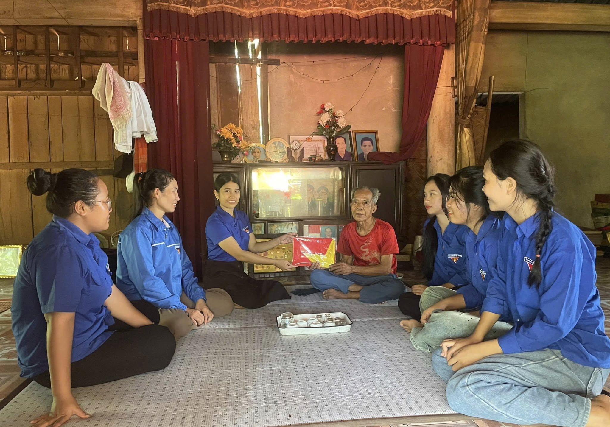 Đoàn viên xã Bến Quan tặng cờ Tổ quốc cho các hộ dân thôn Khe Hó Trù - Ảnh: T.T