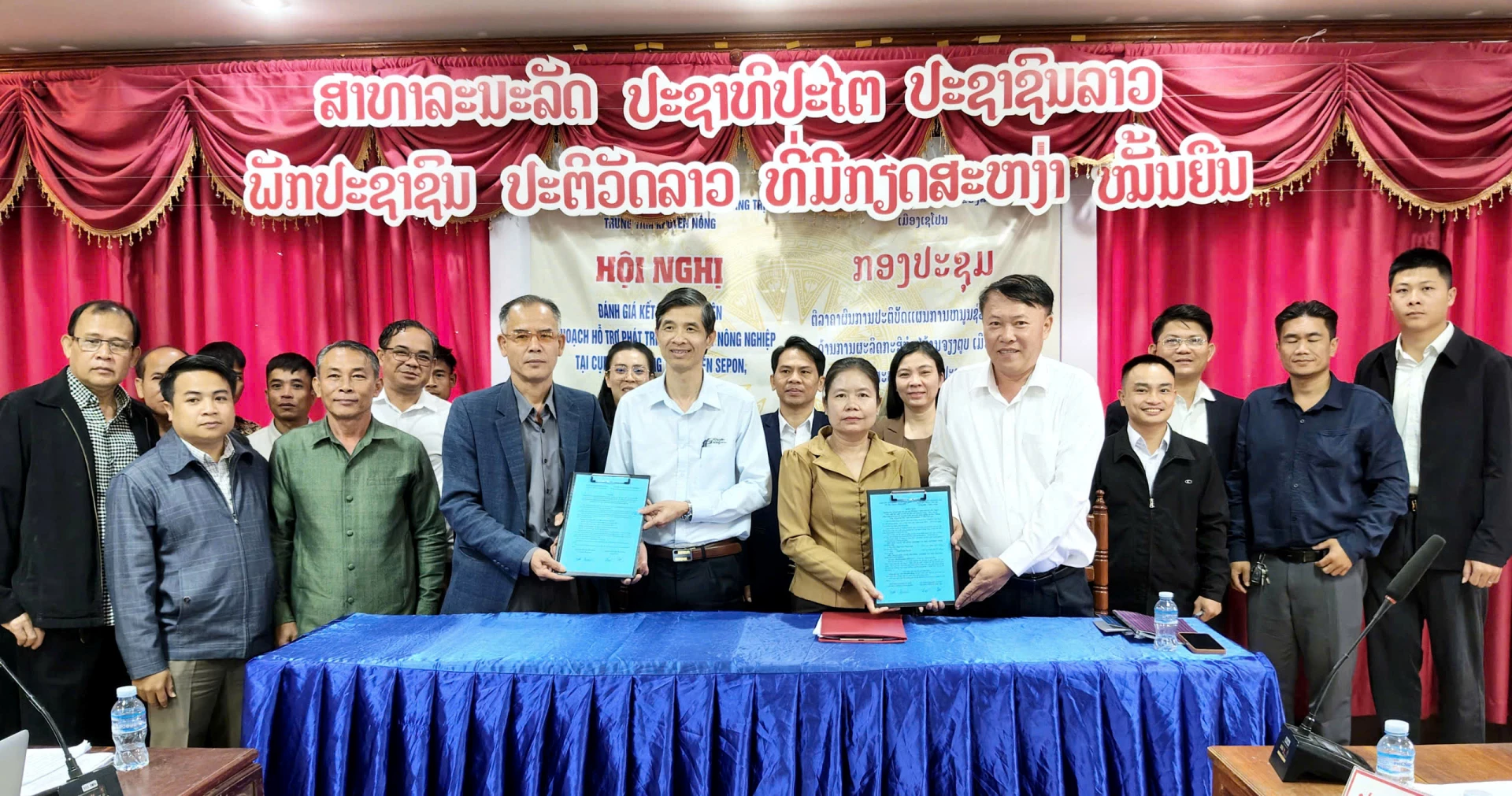 Đại diện lãnh đạo hai sở NN-MT Quảng Trị và Savannakhet ký kết các văn bàn nghiệm thu chương trình hỗ trợ phát triển sản xuất tại cum bản Chiêng Túp-Ảnh: T.Long.