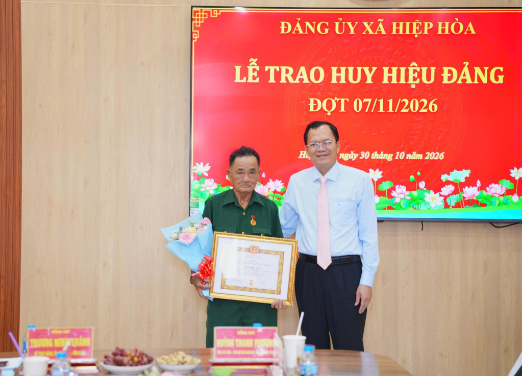 Tỉnh ủy viên, Phó Bí thư chuyên trách Đảng ủy các cơ quan Đảng tỉnh Huỳnh Thanh Phương trao tặng Huy hiệu 55 năm tuổi đảng cho đảng viên Phạm Văn Lượng